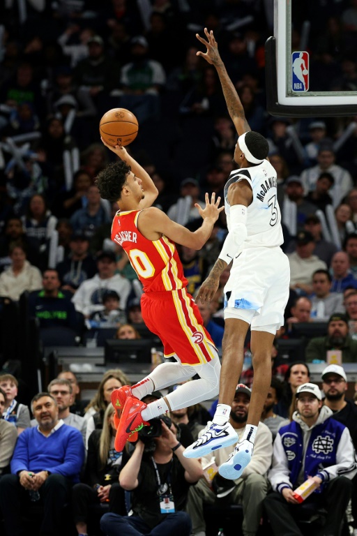 Zaccharie Risacher (g.), l'ailier des Hawks d'Atlanta, tente un tir contre Jaden McDaniels, l'ailier fort des Timberwolves du Minnesota, lors d'un math de saison régulière de NBA à Minneapolis (Minnesota), le 27 janvier 2025