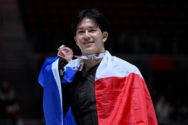 Le Français Adam Siao Him Fa pose avec son drapeau national lors de la cérémonie de remise des médailles de l'épreuve masculine de la Coupe de Chine 2024, à Chongqing, le 23 novembre 2024