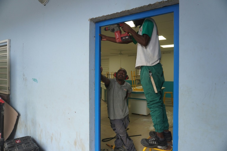 Un ouvrier répare la porte d'une classe du collège Zakia Madi, dans le village de Dembéni à Mayotte, le 22 janvier 2025