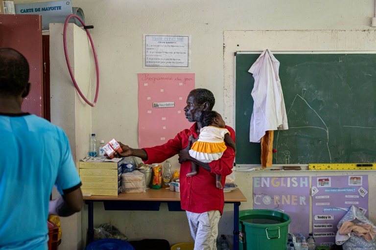 Un homme victime du cyclone Chido bénéficie d'une distribution de nourriture à l'école primaire Paulette Henry de Mamoudzou, le 29 décembre 2024