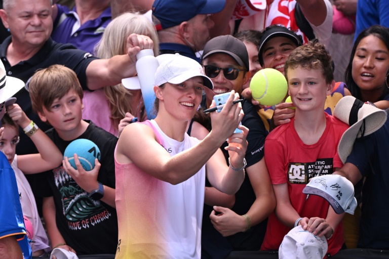 La Polonaise Iga Swiatek pose avec des fans après sa victoire face à la Tchèque Katerina Siniakova au premier tour de l'Open d'Australie, à Melbourne, le 13 janvier 2025