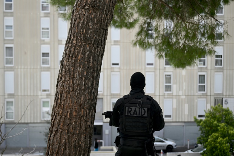 Un policier du raid en position avant la visite du président Emmanuel Macron axée sur la sécurité et la lutte contre le trafic de drogue, dans le quartier de la Castellane à Marseille, le 19 mars 2024