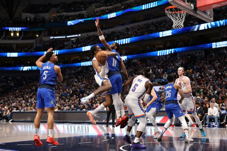 Jalen Williams, l'arrière du Thunder d'Oklahoma City, tente d'approcher le panier face à Kyrie Irving, le meneur des Mavericks de Dallas, pendant un match de saison régulière de NBA, le 17 janvier 2025