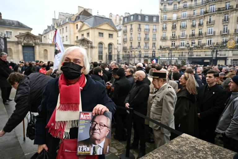 Une femme tenant un magazine rendant hommage à Jean-Marie Le Pen, devant Notre-Dame du Val-de-Grace, Paris, le 16 janvier 2025