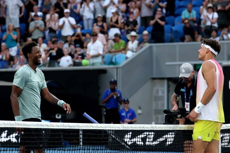 Gaël Monfils (G) s'approche du filet pour abandonner face à Ben Shelton en huitième de finale de l'Open d'Australie, à Melbourne, le 20 janvier 2025