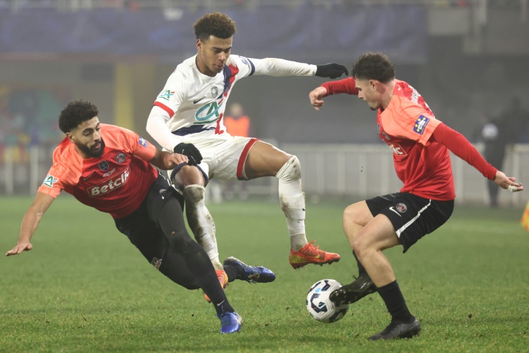 Le milieu de terrain du Paris SG Désiré Doué à la lutte avec deux défenseurs d'Espaly, mercredi soir en 16e de finale de coupe de France au stade Marcel-Michelin de Clermont-Ferrand.