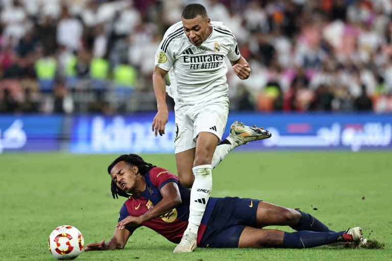 Le défenseur du FC Barcelone Jules Koundé à terre face à l'attaquant du Real Madrid Kylian Mbappe en Supercoupe d'Espagne le 12 janvier 2025 à Jeddah