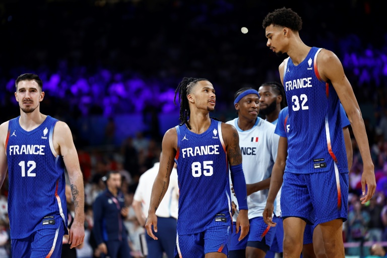 Matthew Strazel (centre) échange avec Victor Wembanyama lors du match de l'équipe de France contre le Japon, aux Jeux olympiques, le 30 juillet 2024 à Villeneuve-d'Ascq