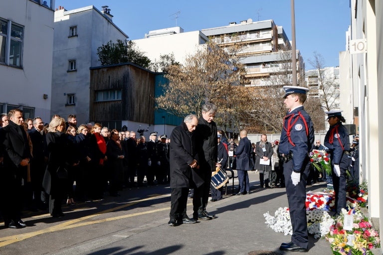 Le président Emmanuel Macron (g) et son épouse Brigitte Macron (2e g) assistent à une cérémonie de dépôt de gerbes lors de la commémoration des 10 ans de l'attentat islamiste contre le journal satirique Charlie Hebdo et le supermarché juif Hypercacher devant les anciens bureaux de l'hebdomadaire, le 7 janvier 2025 à Paris