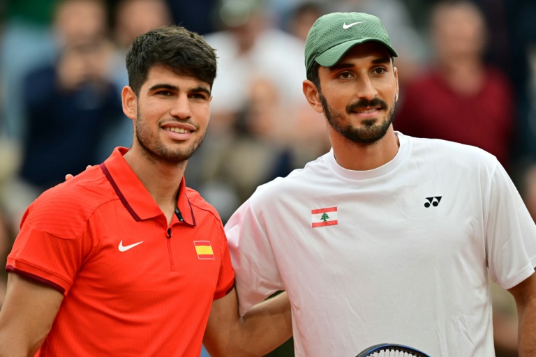 Le Libanais Hady Habib (D) au côté de Carlos Alcaraz lors de leur match au premier tour du tournoi des Jeux olympiques de Paris, à Roland-Garros, le 27 juillet 2024