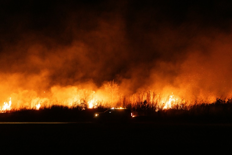 Un camion de pompiers roule le long d'un lit de rivière incendié à Oxnard, au nord-ouest de Los Angeles, en Californie, le 13 janvier 2025