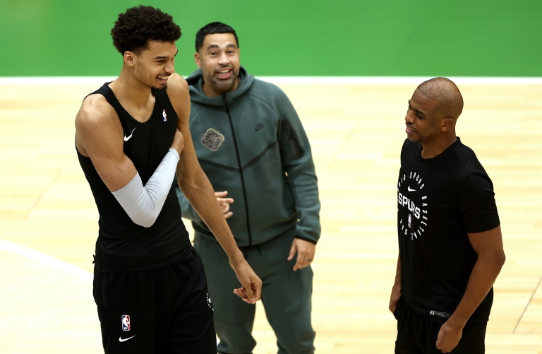 Wemby plaisante avec le meneur des Spurs Chris Paul lors d'une séance d'entraînement à Nanterre, près de Paris, le 20 janvier 2025