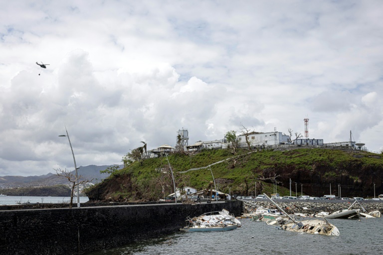 Un hélicopètre de l'armée française survole la ville côtière de Dzaoudzi, à Mayotte, le 28 décembre 2024, deux semaines après le passage du cyclone Chido