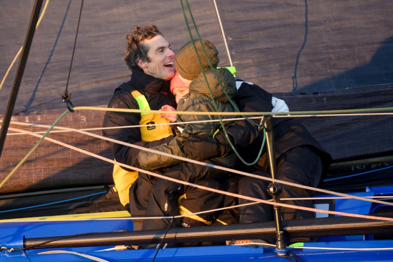 Charlie Dalin embrasse son épouse et son fils après avoir passé en vainqueur la ligne d'arrivée du 10e Vendée Globe, le 14 janvier 2025 aux Sables-d'Olonne