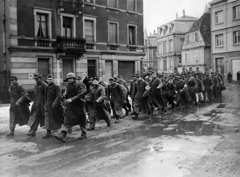 Une colonne de prisonniers allemands traverse les rues de Colmar, le 7 février 1945, cinq jours après la libération de la ville