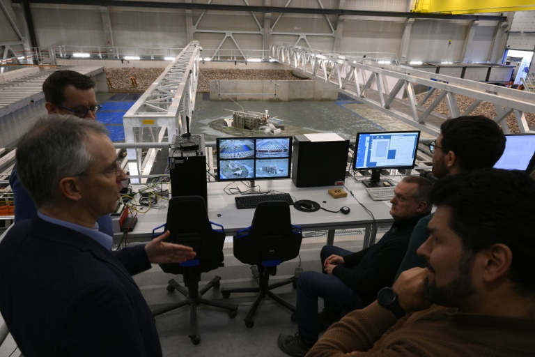 Des chercheurs étudient les effets de la houle et des vagues sur une maquette du fort Boyard dans un bassin à Ostende en Belgique, le 17 février 2025