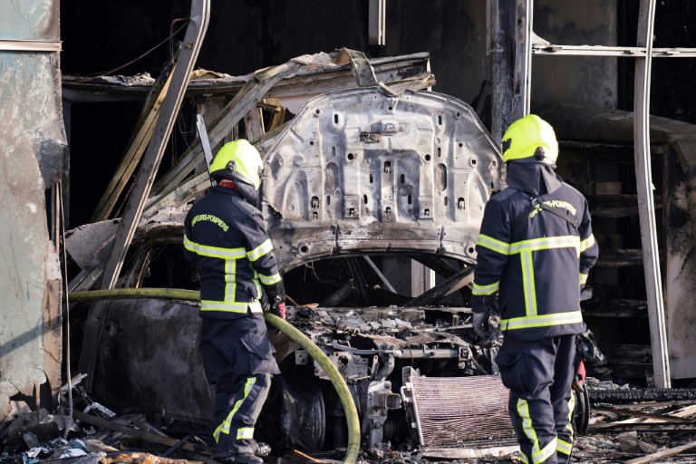 Des pompiers près de la voiture-bélier qui a servi à incendier une bibliothèque à Grenoble, le 19 février 2025