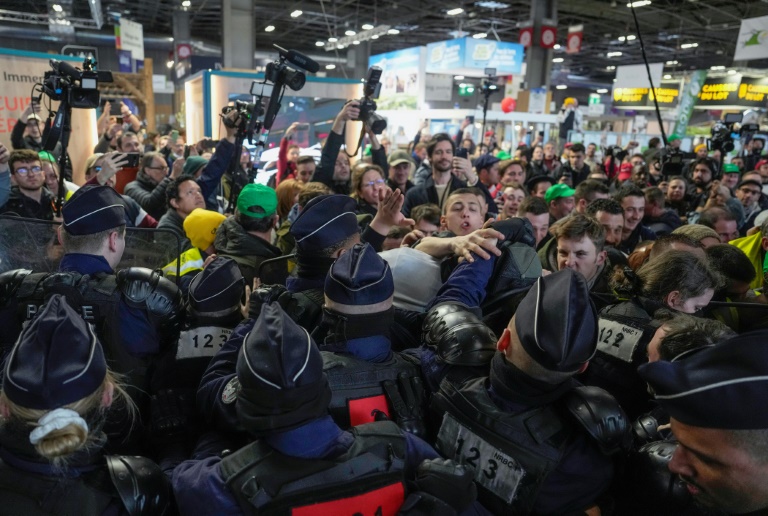 Des agriculteurs en colère se heurtent à des policiers, alors que le président Emmanuel Macron est présent pour l'ouverture du 60e Salon international de l'agriculture, au parc des expositions de la Porte de Versailles, le 24 février 2024 à Paris