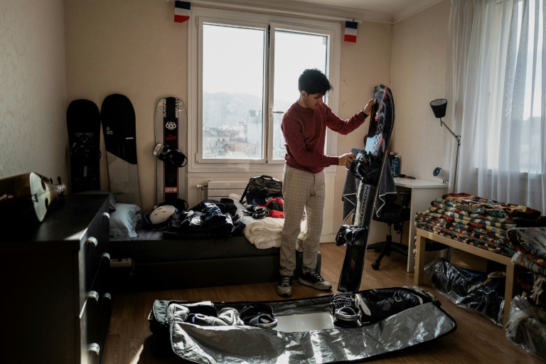 Le réfugié afghan et snowboarder Musawer prépare sa planche dans son appartement à Annecy, le 29 janvier 2025 en Haute-Savoie