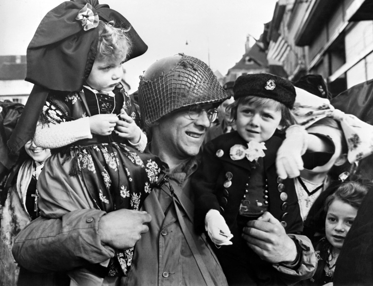 Un soldat américain porte dans ses bras deux jeunes enfants alsaciens, le 7 février 1945 à Colmar, cinq jours après la libération de la ville