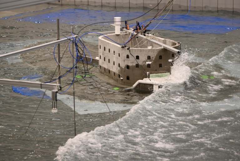 Des chercheurs étudient les effets de la houle et des vagues sur une maquette du fort Boyard dans un bassin à Ostende en Belgique, le 17 février 2025