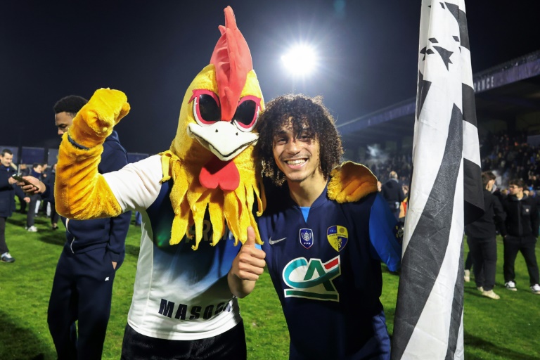 Matheo Ntumi entre la mascotte et le drapeau breton après l'incroyable victoire de son équipe, Saint-Brieuc, contre Nice en Coupe de France le 5 février 2025 à Saint-Brieuc