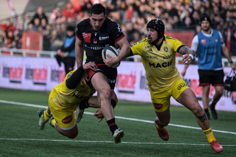 Le demi de mêlée de Lyon Baptiste Couilloud (C) au duel avec les Rochelais Silatolu Latu (G) et Jack Nowell, à Lyon, le 15 février 2025