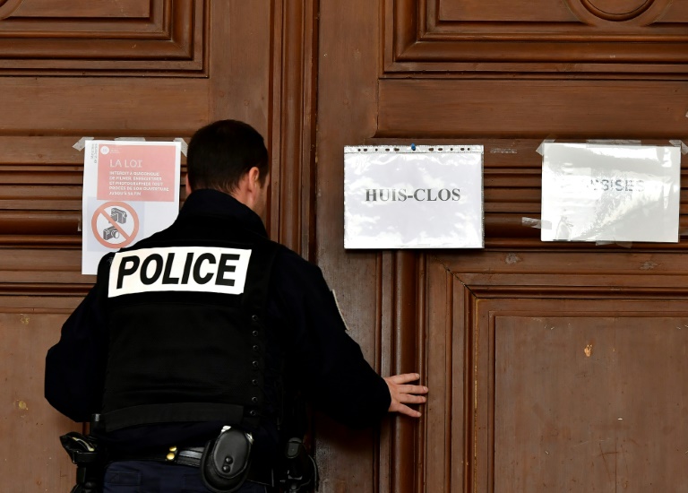 Un policier ferme la porte d'une salle d'audience le 13 mars 2020 lors du procès de Joël Le Scouarnec à Saintes (Charente-Maritime) où il sera condamné à 15 ans de prison pour viols et agressions sexuelles sur quatre enfants