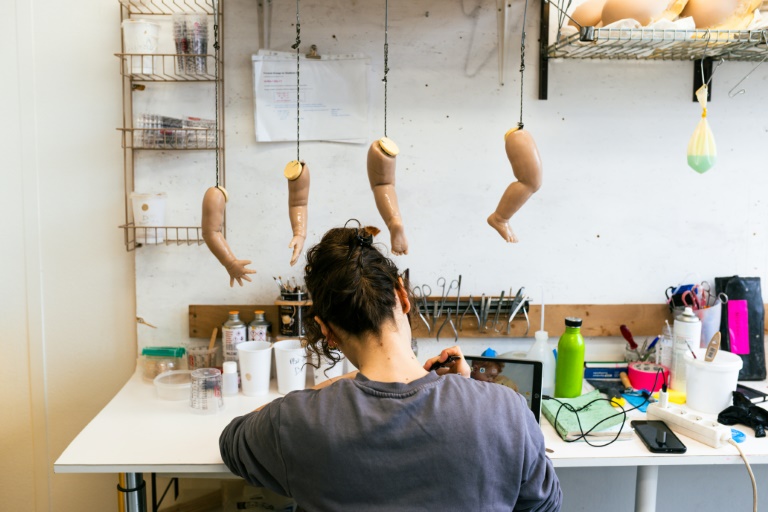 Un technicien d'atelier implante de faux cils sur des bébés en silicone dans les locaux de l'entreprise Cinébébé spécialisée dans la création de poupons hyperréalistes pour des tournages de films ou de séries, le 21 janvier 2025 à Saint-Denis, près de Paris