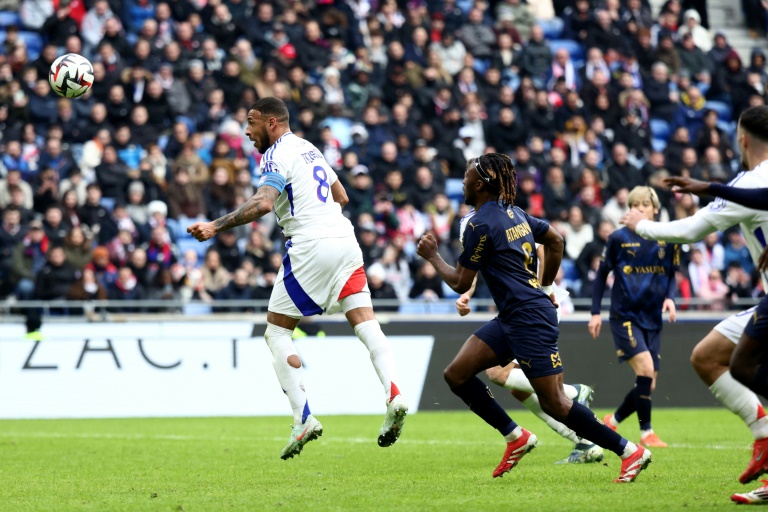 Le milieu de l'OL Corentin Tolisso (gauche) marque le deuxième but de son équipe contre Reims, lors de la 21e journée de L1, le 9 février 2025 à Décines-Charpieu, près de Lyon