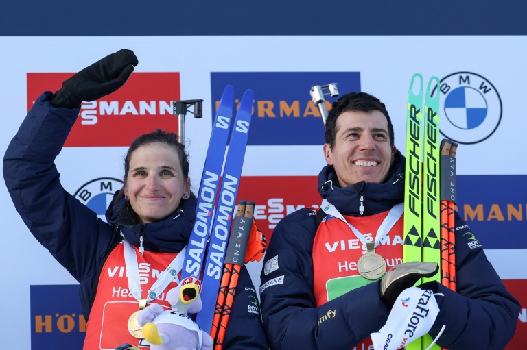 Les Français Julia Simon (à gauche) et Quentin Fillon Maillet (à droite) célèbrent leur victoire dans l'épreuve du relais mixte simple des Championnats du monde de biathlon de Lenzerheide (Suisse), le 20 février 2025