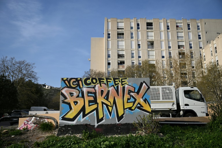 Un graffitt peint sur un mur indiquant l'emplacement d'un trafic de drogue (Here Coffee Bernex) dans le quartier de La Castellane, à Marseille, le 20 mars 2024