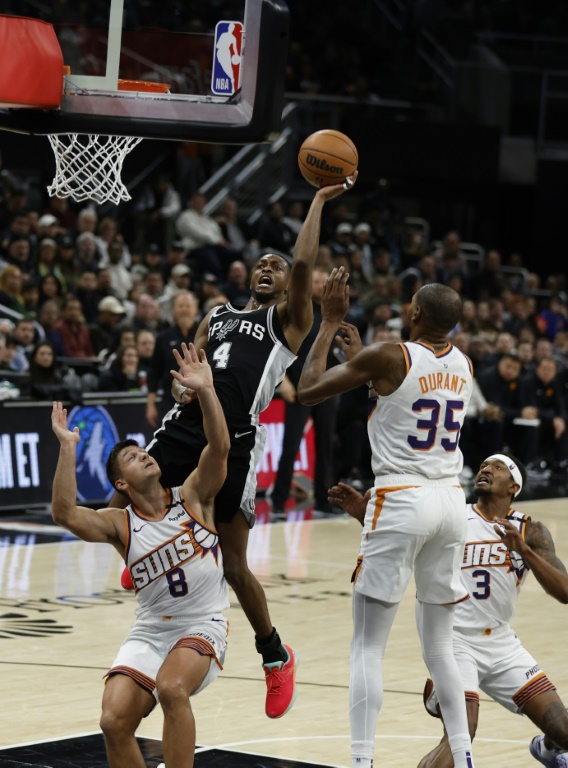 De'Aaron Fox (c.), le meneur des San Antonio Spurs, se dirige vers le panier lors d'un match de NBA contre les Phoenix Suns, à Austin, le 20 février 2025