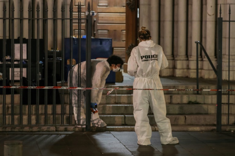 Des membres de la police scientifique devant l'entrée de la basilique Notre-Dame-de-l'Assomption à Nice après une attaque au couteau, le 29 octobre 2020