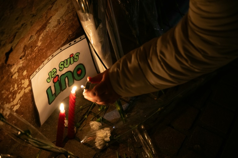 Une femme allume une bougie lors d'un hommage à Lino Sousa Loureiro, à Mulhouse, le 24 février 2025