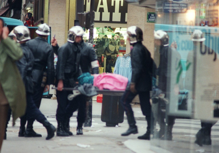 Des pompiers évacuent un blessé, peu après l'explosion d'une bombe au rez-de-chaussée du magasin Tati, rue de Rennes à Paris, le 17 septembre 1986