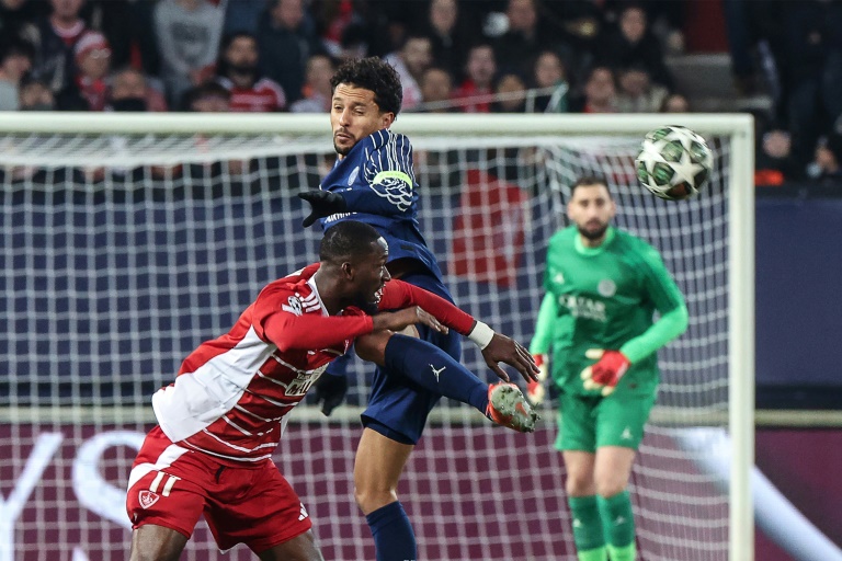 Le capitaine parisien Marquinhos à la lutte avec l'attaquant sénégalais de Brest Abdallah Sima lors du barrage aller d'accession aux huitièmes de finale de la Ligue des champions le 11 février 2025 à Guingamp