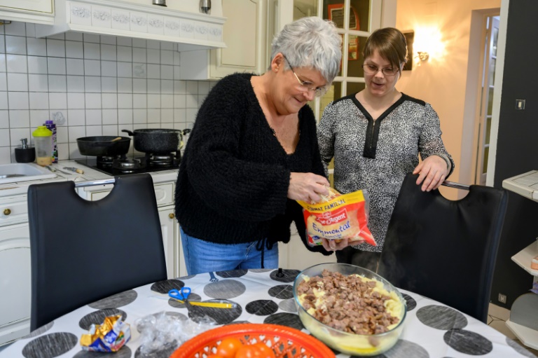 Sylvie Oswald (g) prépare le repas avec Stéphanie, l'une des personnes qu'elle accueille chez elle, le 25 février 2025 à Neufmaisons, en Meurthe-et-Moselle