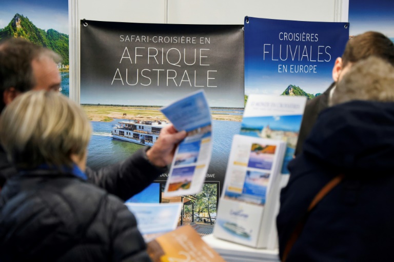 Des visiteurs s'informent sur les croisières au stand de CroisiEurope lors du Salon mondial du tourisme à Paris, le 13 mars 2025