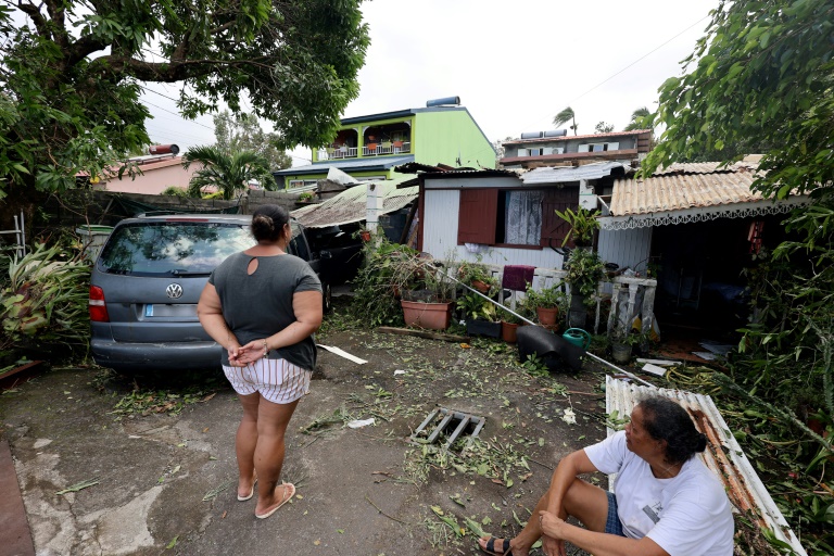 Des habitantes devant une maison dévastée par le cyclone Garance à Sainte-Anne, sur l'île de La Réunion, le 1er mars 2025