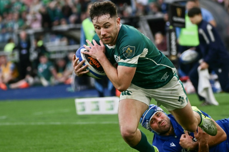 L'Irlandais Hugo Keenan (à gauche) échappe à un plaquage de l'Italien Gianmarco Lucchesi lors de la dernière journée du tournoi des 6 nations le 15 mars 2025 dans le Stadio Olimpico de Rome