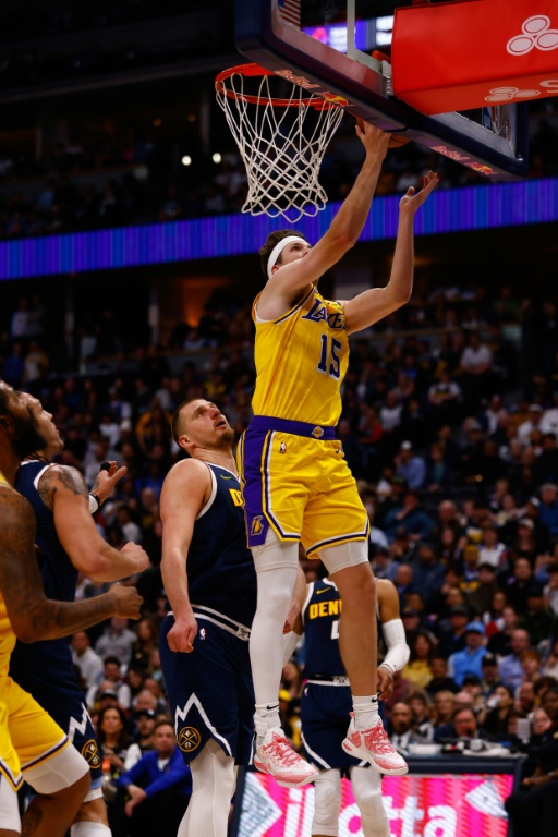 Austin Reaves, l'arrière des Lakers de Los Angeles, marque devant Nikola Jokic, le pivot serbe des Nuggets de Denver, lors d'un match de saison régulière de la NBA, à Denver, le 14 mars 2025