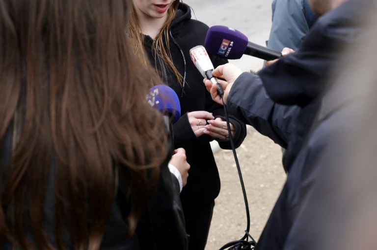 Une lycéenne parle à la presse le 25 mars 2025 devant le lycée Louis Armand  à Yerres, en banlieue parisienne, au lendemain du décès d'un adolescent de 17 ans poignardé devant l'établissement