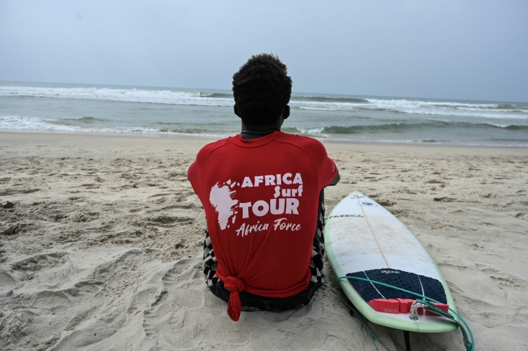 Un surfeur participant au Africa Surf Tour attend la vague le 22 février 2025 sur la plage ivoirienne d'Assinie