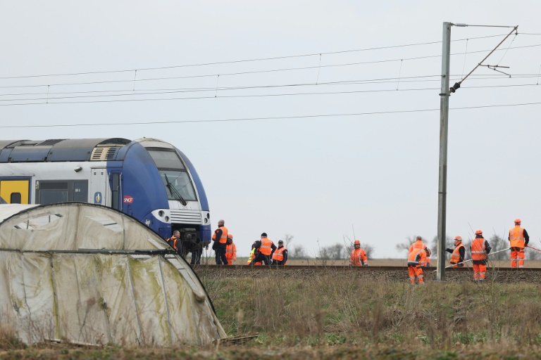 Des gendarmes et des personnels de la SNCF sur les lieux d'une collision entre un TER et un véhicule militaire sur un passage à niveau, à Bailleul-Sir-Berthoult, dans le Pas-de-Calais, le 17 mars 2025