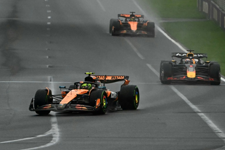 Le pilote britannique de McLaren Lando Norris (g.) mène la course devant le pilote néerlandais de Red Bull Racing Max Verstappen (d.) et le pilote australien de McLaren Oscar Piastri lors du Grand Prix d'Australie de Formule 1, sur le circuit d'Albert Park à Melbourne, le 16 mars 2025