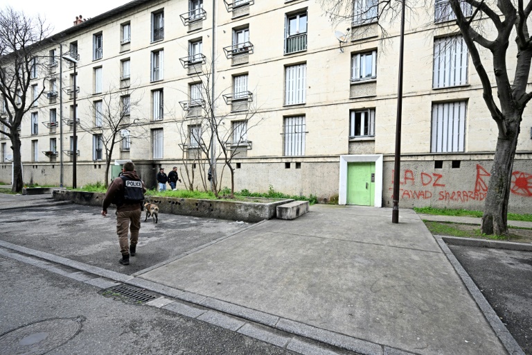 Un policier marche devant un bâtiment utilisé par un narcotrafiquant présumé, le 13 mars 2025 à Avignon