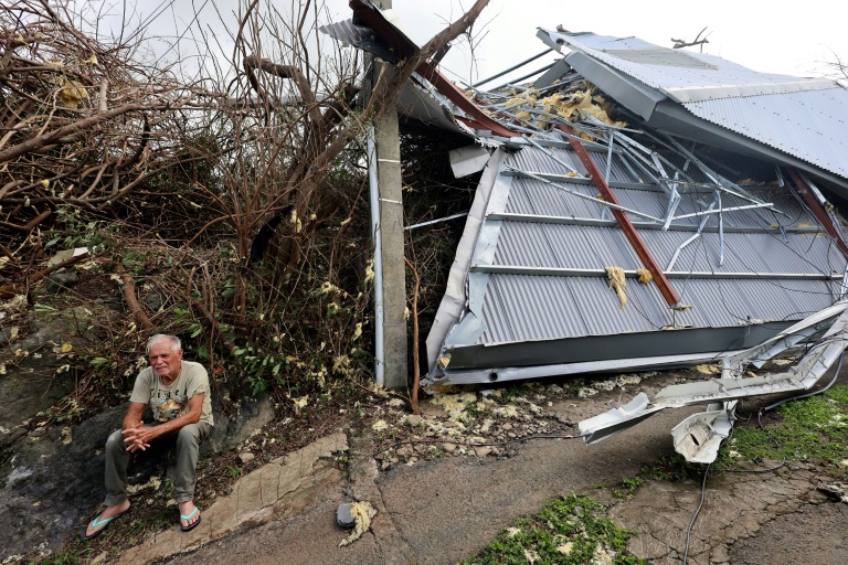 Un habitant est assis devant une maison détruite par le cyclone Garance à Saint-Benoit, sur l'île de La Réunion, le 1er mars 2025