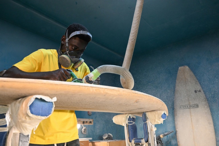 Eric Kouakou, un fabricant de planche, au travail à la West Factory, seul atelier de fabrication de planches de surf de Côte d'Ivoire le 25 février 2025 à Abidjan