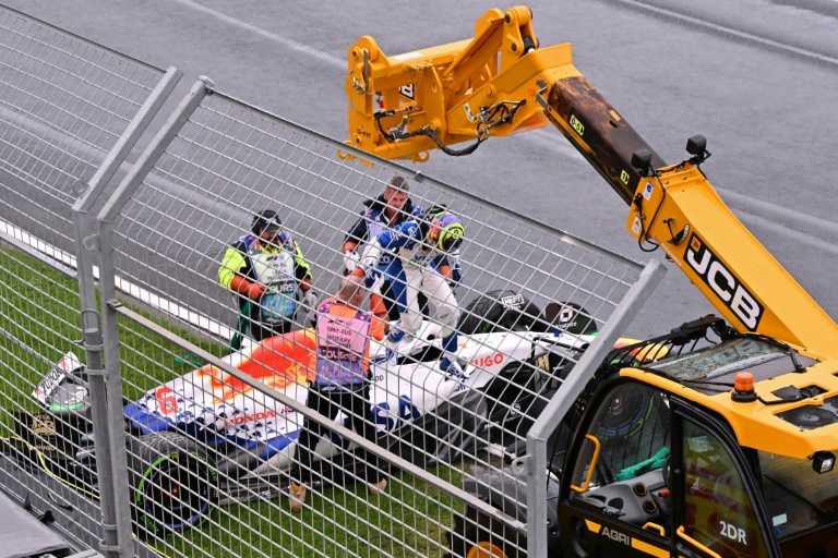 Le pilote français de Racing Bulls, Isack Hadjar (c.), quitte sa voiture après avoir subi une sortie de piste pendant le tour de formation avant le départ du Grand Prix d'Australie de F1, à Melbourne, le 16 mars 2025